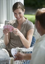 Couple playing card game on porch.