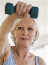 Senior woman lifting hand weight.