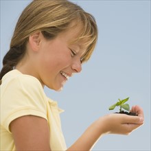Girl holding seedling.