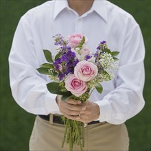 Man holding bouquet of flowers.
