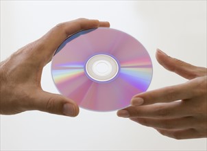 Close up of hands and compact disc.