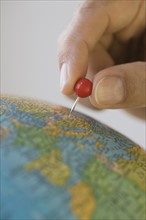 Close up of pin marking place on globe.