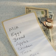 Close up of grocery list and money.