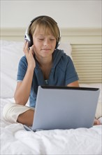 Girl listening to music on laptop.