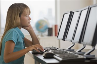 Girl using laptop in classroom.