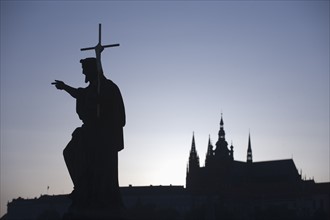 Silhouetted statue and cathedral.