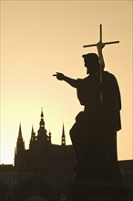 Silhouetted statue and cathedral.