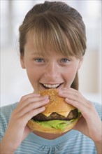 Girl eating hamburger.