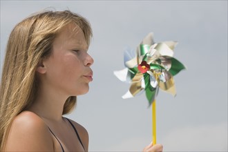 Girl blowing on pinwheel.