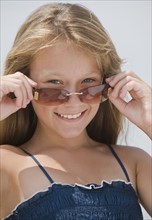 Girl looking over sunglasses.