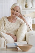Senior woman relaxing in livingroom.