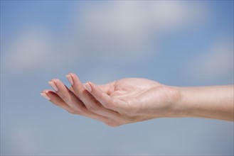 Close up of hand against sky.