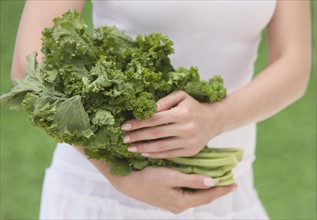 Woman holding fresh kale.