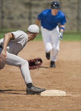 Baseball player trying to steal base.