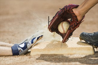 Baseball player sliding into home base.