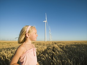 Girl in tall wheat field on wind farm. Date : 2008