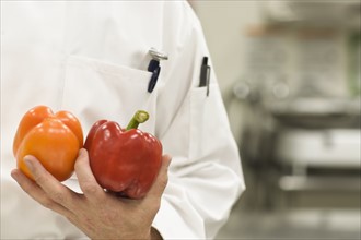 Chef holding bell peppers. Date : 2008