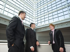 Businessmen socializing in convention center atrium. Date : 2008