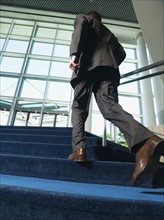 Businessman ascending office building stairs. Date : 2008