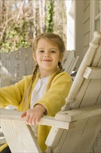 Girl sitting in chair on porch. Date : 2008
