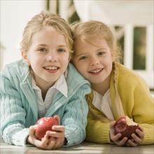 Sisters eating apple on porch. Date : 2008