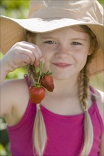 Girl holding fresh strawberries. Date : 2008