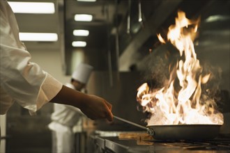 Chef holding flaming pan. Date : 2008