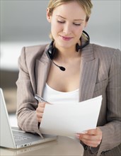 Businesswoman reviewing paperwork. Date : 2008