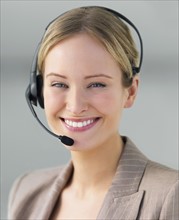 Portrait of businesswoman wearing telephone headset. Date : 2008