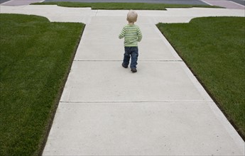 Baby boy walking on sidewalk. Date : 2008
