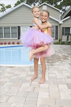 Girls in tutus playing by swimming pool. Date : 2008