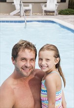 Father and daughter posing by swimming pool. Date : 2008