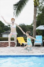 Girls jumping into swimming pool. Date : 2008