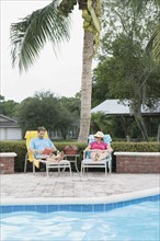Couple relaxing poolside. Date : 2008