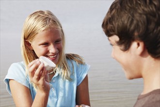 Girl showing shell to friend. Date : 2008