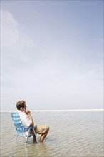 Man talking on cell phone in middle of water. Date : 2008