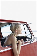Young woman sitting in van on beach. Date : 2008