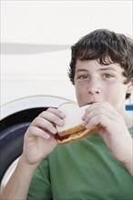 Boy eating peanut butter and jelly sandwich. Date : 2008