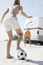 Young couple playing soccer on beach. Date : 2008