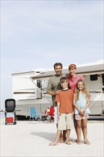 Family posing by motor home on beach. Date : 2008