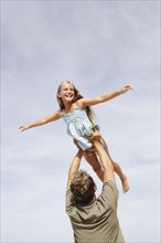 Father lifting daughter in air. Date : 2008