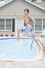 Boy jumping into swimming pool. Date : 2008