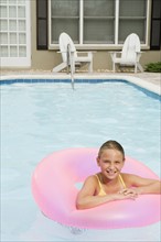 Girl floating on inflatable ring in swimming pool. Date : 2008