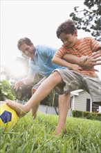 Father and son playing soccer in backyard. Date : 2008