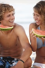 Young couple eating watermelon on beach. Date : 2008