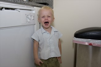 Baby boy crying in kitchen. Date : 2008
