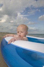 Baby boy sitting in inflatable swimming pool. Date : 2008