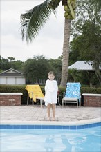 Girl standing at edge of swimming pool. Date : 2008