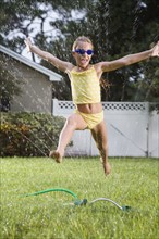 Girl running through sprinkler. Date : 2008