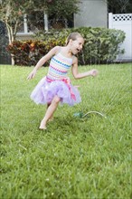 Girl running through sprinkler. Date : 2008